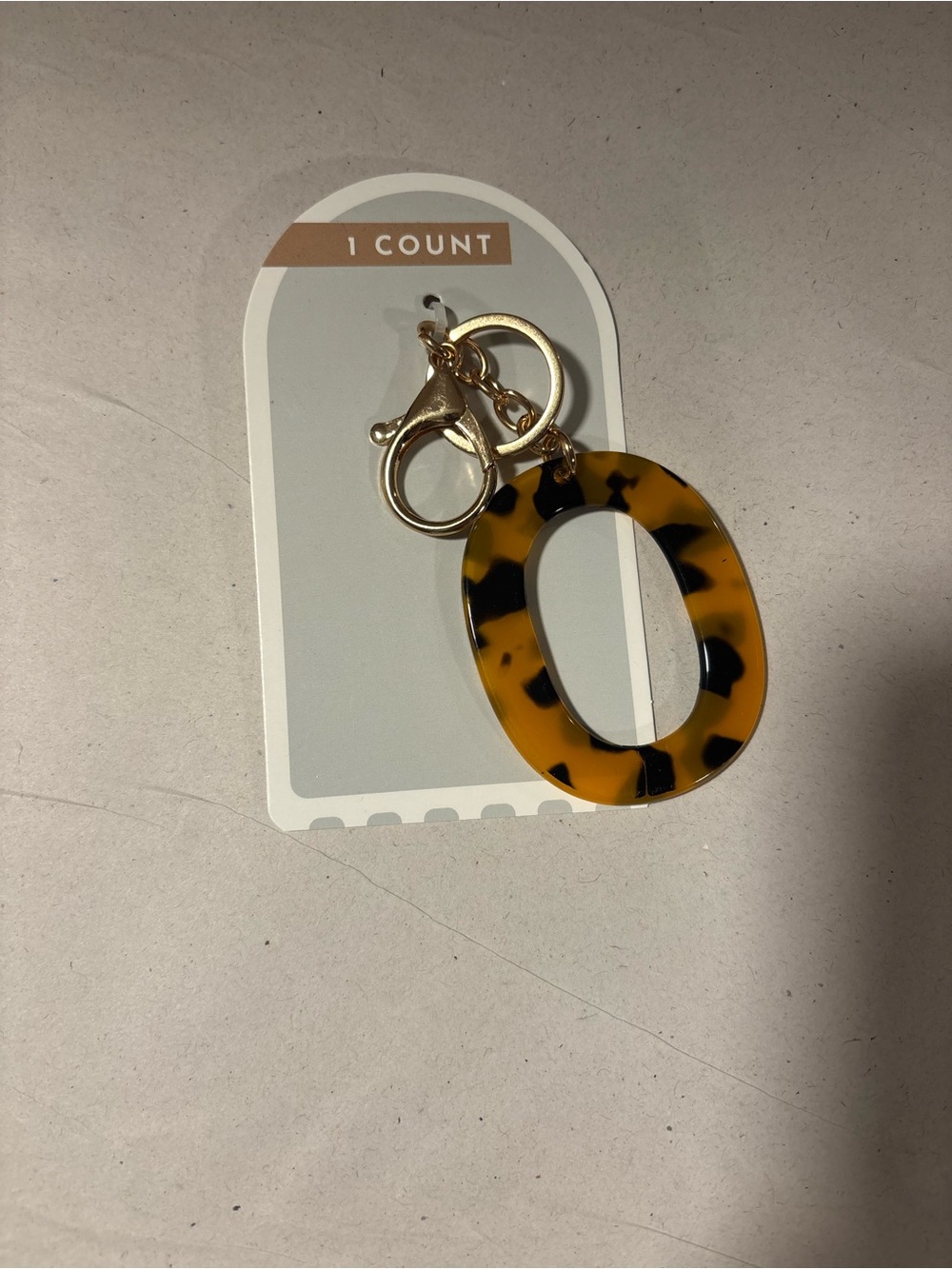 tortoise-shell monogram letter "O" charm keychain featuring gold-tone hardware